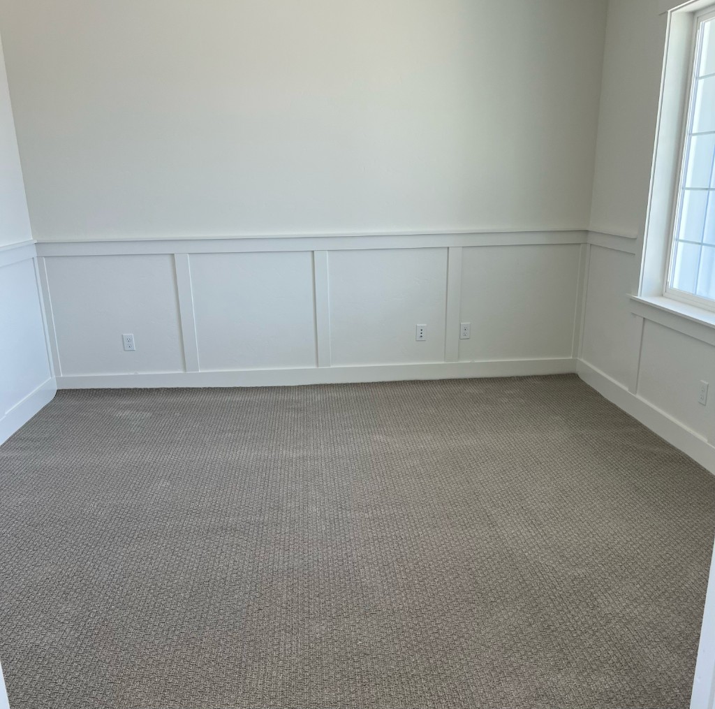 Carpet installation with light grey patterned broadloom, padding, and wainscot trim by Kraft Floors & Interiors